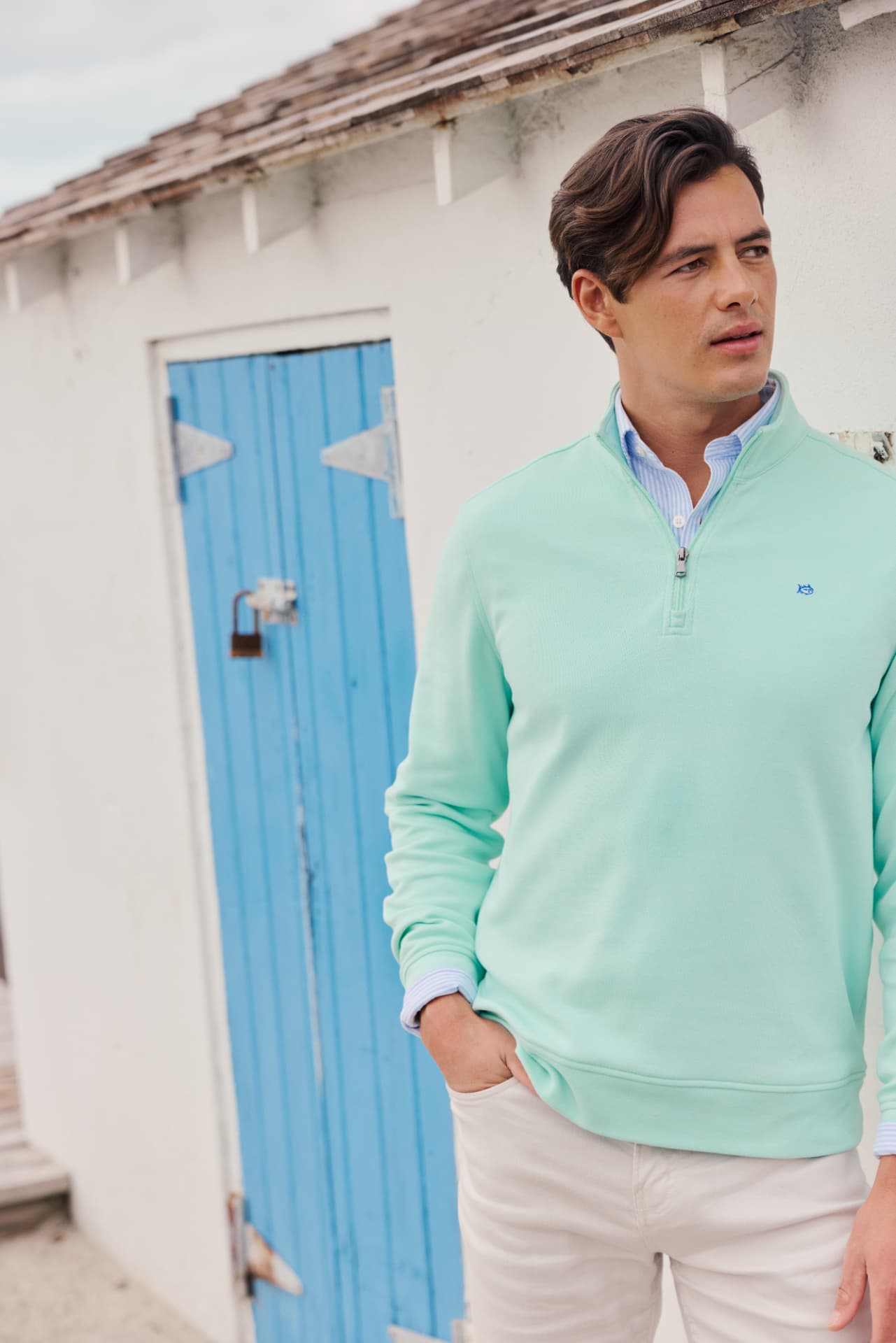Mint quarter-zip knit layered over a striped sport shirt